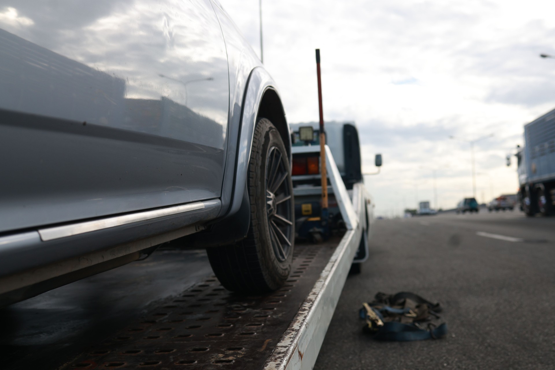 Loading a car onto a tow truck. A broken-down vehicle on the highway receives expert care from a tow truck, getting back on track for a safe and hassle-free journey.